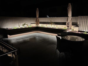 Natura-dark-brown-composite-decking-raised-seating-area-night